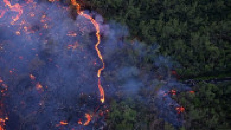 Fotografie aeriană cu oameni adunați pentru a urmări un flux de lavă de la vulcanul Piton de la Fournaise, în Saint-Philippe, pe insula Reunion, 2 aprilie 2026. Foto: Profimedia Images | Poza 2 din 6