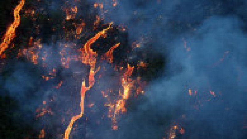 Fotografie aeriană cu oameni adunați pentru a urmări un flux de lavă de la vulcanul Piton de la Fournaise, în Saint-Philippe, pe insula Reunion, 2 aprilie 2026. Foto: Profimedia Images | Poza 3 din 6