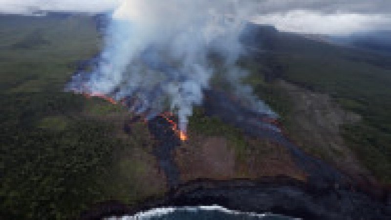 Fotografie aeriană cu oameni adunați pentru a urmări un flux de lavă de la vulcanul Piton de la Fournaise, în Saint-Philippe, pe insula Reunion, 2 aprilie 2026. Foto: Profimedia Images | Poza 5 din 6