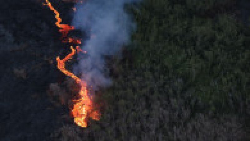Fotografie aeriană cu oameni adunați pentru a urmări un flux de lavă de la vulcanul Piton de la Fournaise, în Saint-Philippe, pe insula Reunion, 2 aprilie 2026. Foto: Profimedia Images | Poza 4 din 6