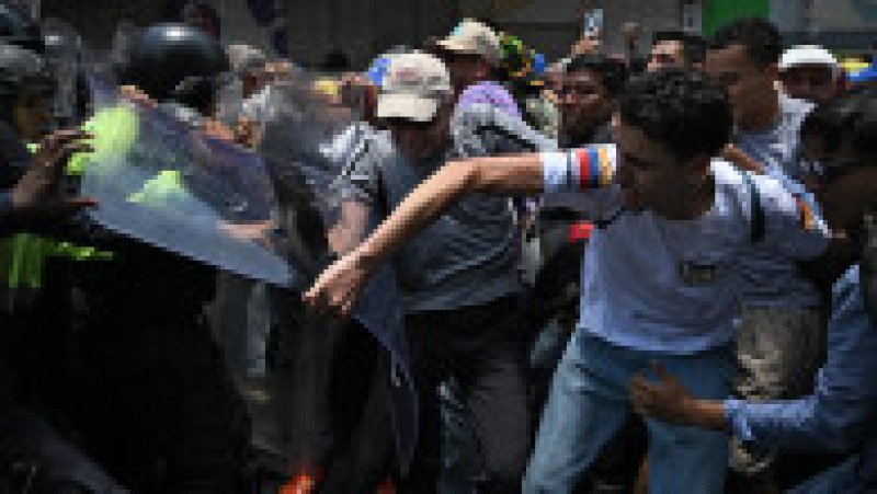 Oponenţi ai preşedintei interimare Delcy Rodriguez protestează la Caracas, pe 9 aprilie 2026, cerând majorarea salariilor şi pensiilor, cu un uriaş drapel venezuelean. Foto: Profimedia Images | Poza 8 din 8