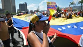 Oponenţi ai preşedintei interimare Delcy Rodriguez protestează la Caracas, pe 9 aprilie 2026, cerând majorarea salariilor şi pensiilor, cu un uriaş drapel venezuelean. Foto: Profimedia Images | Poza 1 din 8